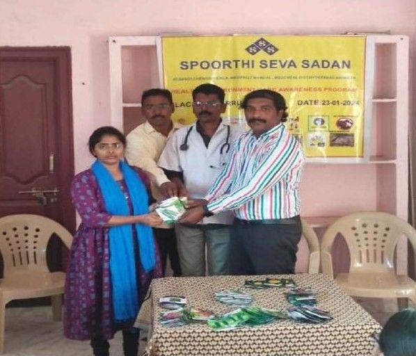 A doctor and trust members handing seed packets to a participant at a health awareness program